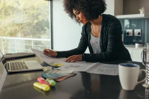 Homeowner reviewing insurance policy paperwork at a kitchen counter